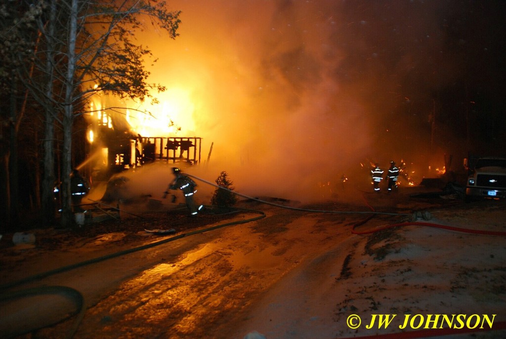 Firefighter Drags Hose to Front Corner of House